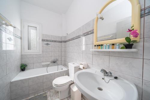 a bathroom with a sink and a toilet and a tub at Kallithea Studios & Apts in Lakíthra