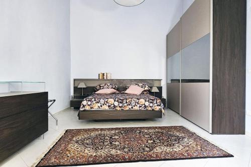 sypialnia z łóżkiem z poduszkami i dywanem w obiekcie Residenza Palazzo Miraldi-Ferrari w mieście Cava deʼ Tirreni