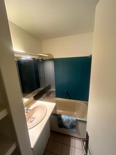 ein Badezimmer mit einem Waschbecken und einer Badewanne in der Unterkunft ESCAPADE FAMILIALE A LA MER in Quiberon