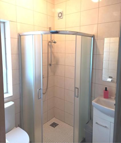 a shower with a glass door in a bathroom at Anetta Domki Mielno in Mielno