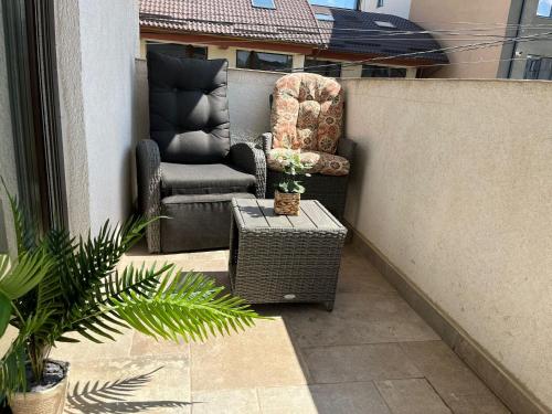 patio z 2 krzesłami, stołem i ogrodzeniem w obiekcie Holidays Makerel Lodge Vibes Mamaia Nord w mieście Năvodari