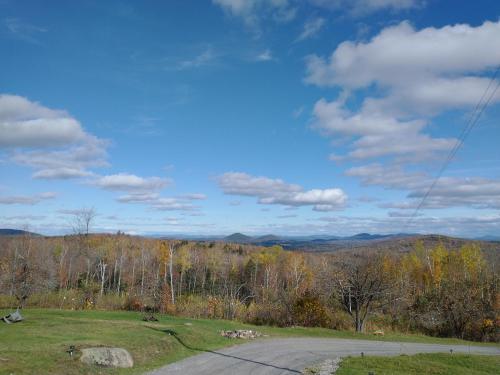 una carretera en medio de un campo junto a una montaña en Adirondack Retreat, en Bakers Mills