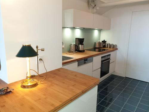 une cuisine avec une table et une lampe. dans l'établissement Villa Familia, à Grandcamp-Maisy