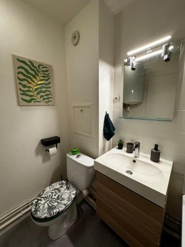 une salle de bain avec toilettes et lavabo dans l'établissement Un cocon tout confort, à Osny