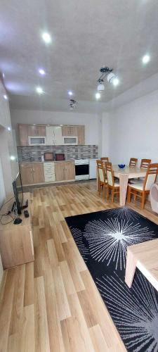 a large living room with a table and a kitchen at ARIA in Mitrovica