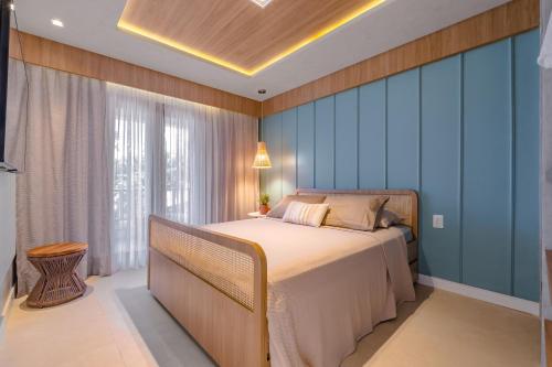 een slaapkamer met een bed en een blauwe muur bij Apartamento de Charme no Cumbuco - Condomínio Jardim Reale in Caucaia