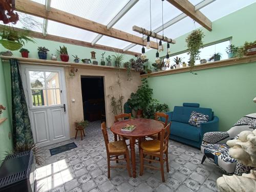 un salon avec une table et un canapé dans l'établissement Gîte des 4 chemins Parc Naturel Baie de Somme, à Saint-Blimont