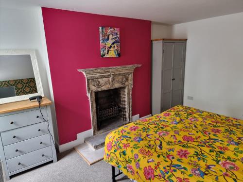 a bedroom with a bed and a fireplace at Entire Ground Floor Flat, Free Off-Street Parking and Large Garden in London