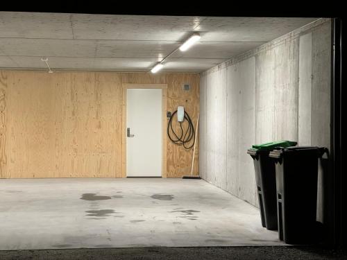 una habitación vacía con una puerta y dos cubos de basura en Moderne topp leilighet, 