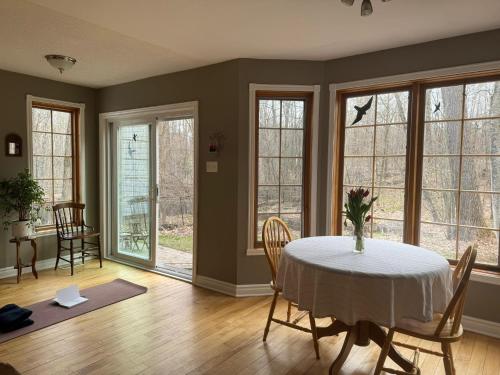 a dining room with a table and chairs and windows at Marley's home in Woodlawn