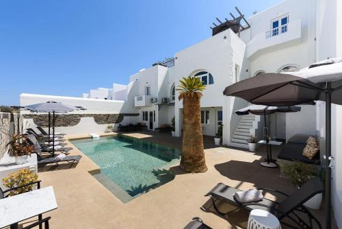 a villa with a swimming pool and white buildings at Vammos Luxury Apartments in Naousa