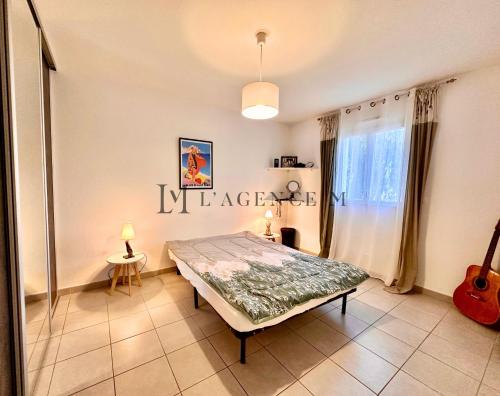 - une chambre avec un lit et un panneau de bienvenue sur le mur dans l'établissement Appartement Cardellu Paisible & centre-ville CALVI, à Calvi