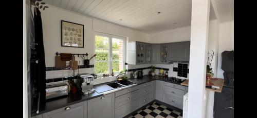 a kitchen with a black counter top and a window at Maison de maître avec piscine in Quetteville