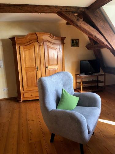 a blue chair with a green pillow in a room at Hotel Landhaus Sternen in Sipplingen