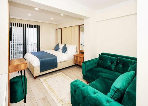 uma sala de estar com uma cama e um sofá verde em GRAND VİCTORY OTEL em Arnavutköy