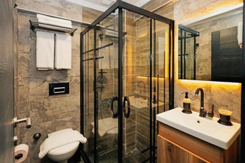 uma casa de banho com um chuveiro, um WC e um lavatório. em GRAND VİCTORY OTEL em Arnavutköy