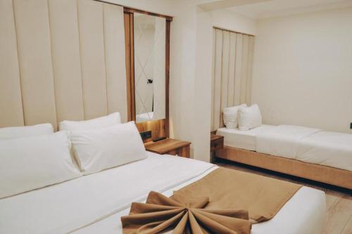 una camera d'albergo con due letti e uno specchio di GRAND VİCTORY OTEL a Arnavutköy