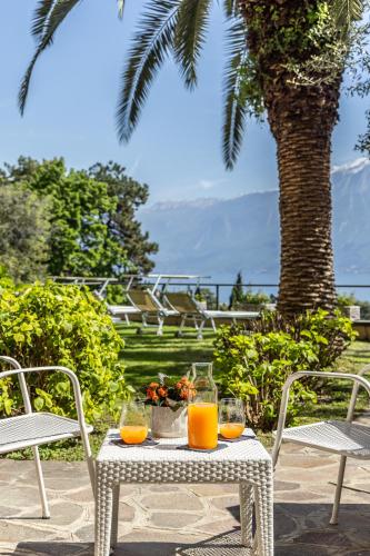 a table with two glasses of orange juice on it at Hotel Meandro - Lake View in Gargnano