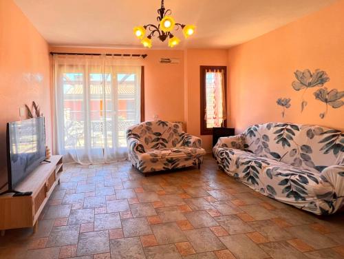 a living room with a couch and a tv at Villa La Terrazza in Porto Santo Stefano