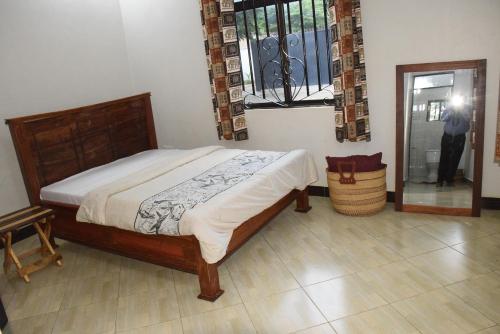 a bedroom with a bed and a person standing in a doorway at Beatrice James airbnb Moshi in Moshi