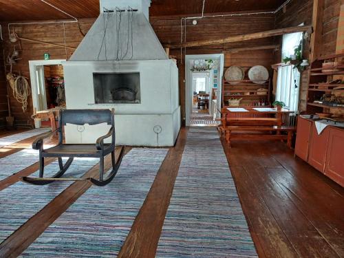 a living room with a chair and a fireplace at Ranta-Keurula in Kärkkäälä