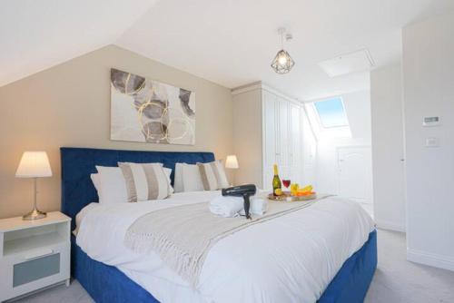 una camera con un grande letto con testiera blu di Wavendon Retreat - Sleeps 6 - Free Parking, Fast Wifi and Smart TV by YOKO PROPERTY a Milton Keynes