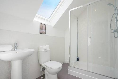 a bathroom with a toilet and a sink and a shower at Wavendon Retreat - Sleeps 6 - Driveway Parking, Self-Check-In, Fast Wifi and Smart TV by YOKO PROPERTY in Milton Keynes