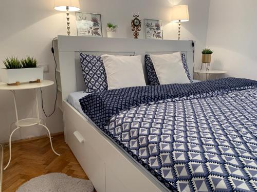 een slaapkamer met een bed met een blauw en wit dekbed bij Á Citadelle de Caroline in Alba Iulia