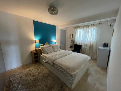 une chambre avec un lit et un mur bleu dans l'établissement Bas de villa chez Marta, à Antibes