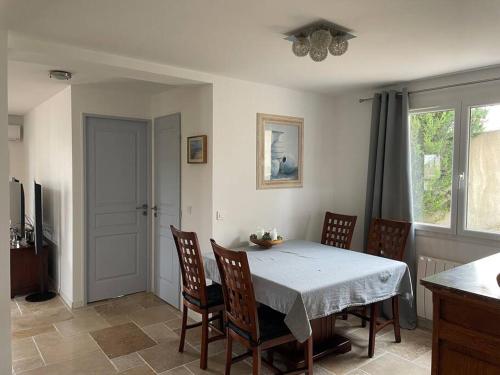 une salle à manger avec une table et des chaises blanches dans l'établissement Bas de villa chez Marta, à Antibes