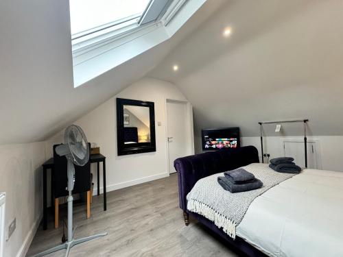 a bedroom with a bed with a mirror and a window at Gorgeous Loft Room in Beckenham