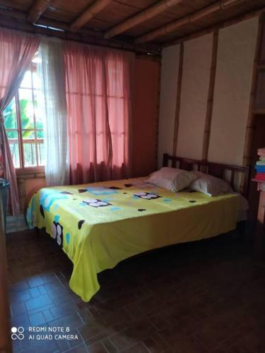 ein Schlafzimmer mit einem Bett mit einer gelben Decke darauf in der Unterkunft Hermosa casa campestre in Popayan