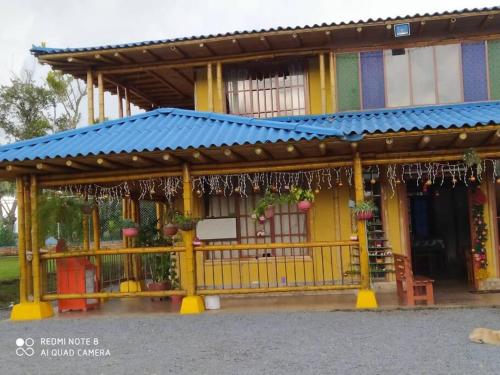 żółty budynek z niebieskim dachem w obiekcie Hermosa casa campestre w mieście Popayán