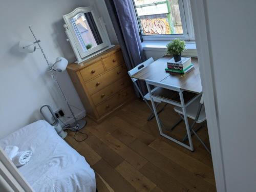 Moonwalk في لندن: غرفة نوم صغيرة بها مكتب وسرير ونافذة