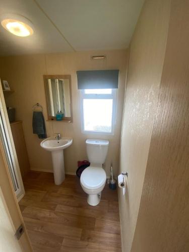 a bathroom with a toilet and a sink at 15 Maple Rise in Gristhorpe