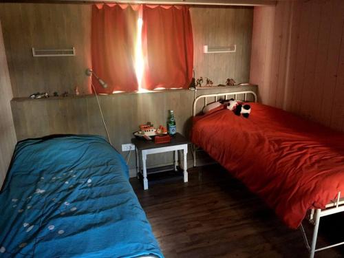 a bedroom with two beds and a table with a lamp at Maison bord de mer in La Tranche-sur-Mer