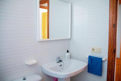 Baño blanco con lavabo y espejo en Apartamento con piscina en Playa de Gandía en Playa de Gandia