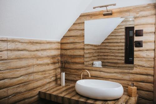 ein Badezimmer mit einer weißen Badewanne und einer Holzwand in der Unterkunft Rustic Wood Villa in Liban