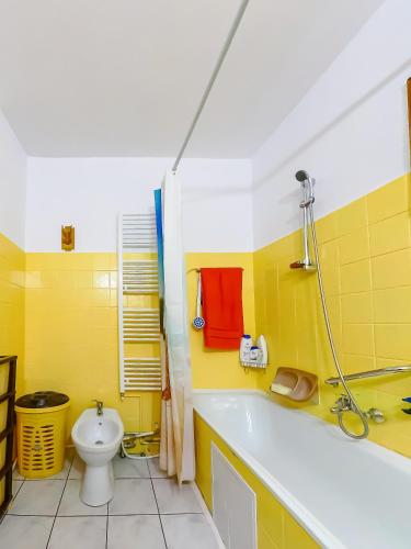 a yellow bathroom with a tub and a toilet at Casa Ionela in Câmpulung Moldovenesc