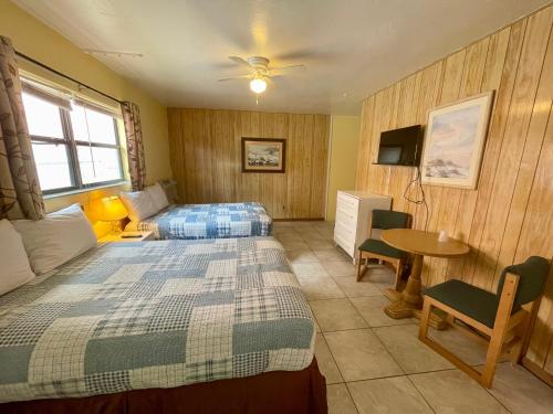 Ocean Holiday Motel في دايتونا بيتش: غرفة نوم بسرير وطاولة واريكة