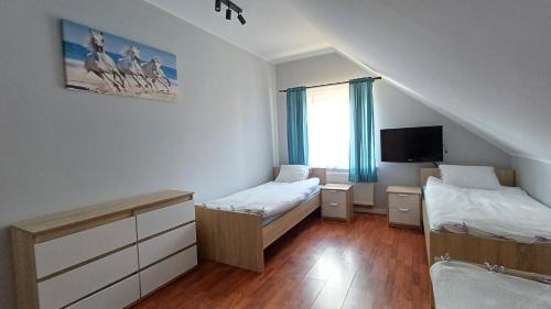 a small room with two beds and a tv at Magnum Nadole in Nadole