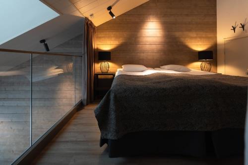 1 dormitorio con 1 cama y pared de cristal en Kultakero Northern Sky en Pyhätunturi