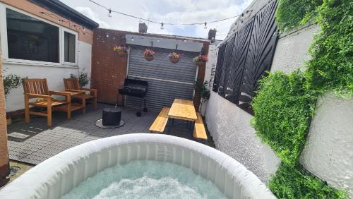a hot tub in the backyard of a house at Cabin of Light - Hot Tub, Sauna, Massage Chair, BBQ, Games, Beach in Monkwearmouth