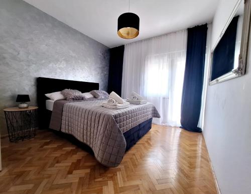 a bedroom with a bed and a wooden floor at Apartment Lucy Zadar - free private parking in Zadar