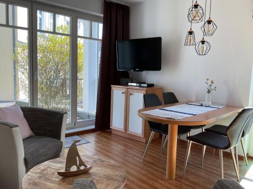 a living room with a table and chairs and a tv at Villa Granitz Appartement FeWo 21 in Göhren - nur paar Schritte bis zum Strand in Göhren