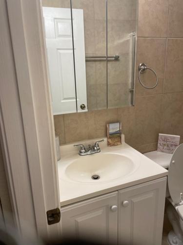 een badkamer met een wastafel, een spiegel en een toilet bij Home away from home in West Palm Beach