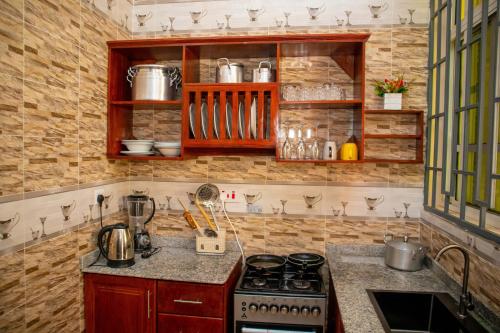 a kitchen with a stove and a counter top at Villa Home Apartment Dodoma in Dodoma