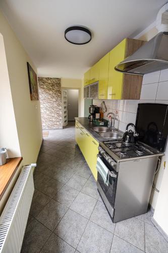 a kitchen with yellow cabinets and a stove top oven at Domek przy Rynku in Głogówek