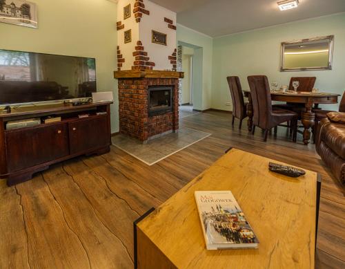 a living room with a fireplace and a table at Domek przy Rynku in Głogówek