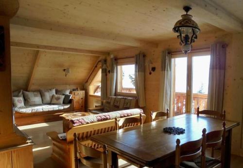 a dining room with a table and a couch at Chalet Savoyard vue panoramique in Jarrier